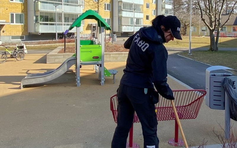 Ung kvinna som krattar löv i ett bostadsområde