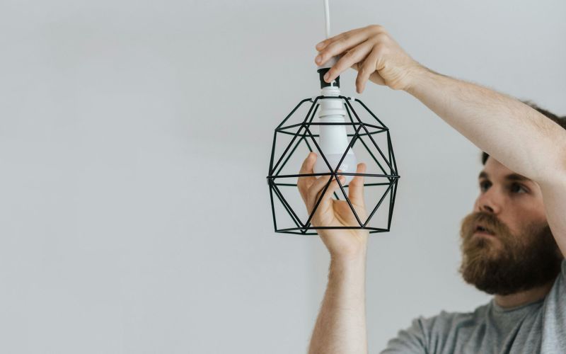 en man byter glödlampa