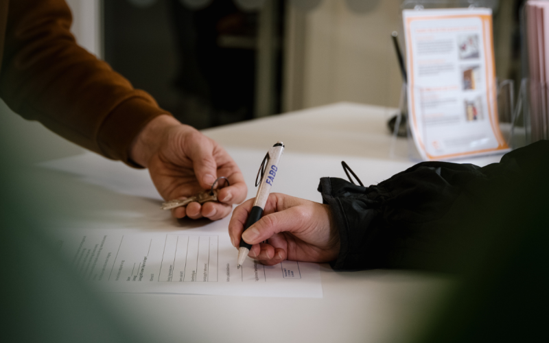 Två personer, vars händer bara syns över ett papper - den ena skriver under ett kontrakt