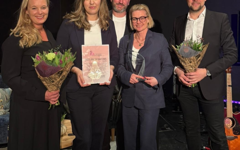 Fem personer som har tagit emot pris och blommor