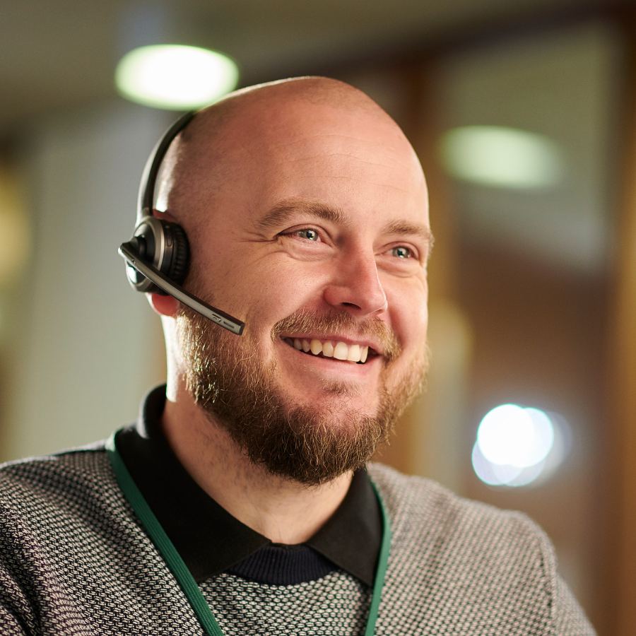 Glad man med headset, redo svara i telefon