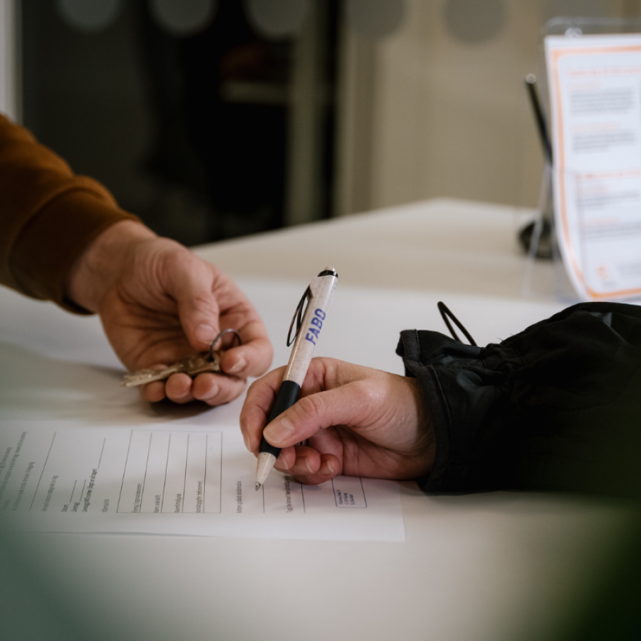 Två personer, vars händer bara syns över ett papper - den ena skriver under ett kontrakt