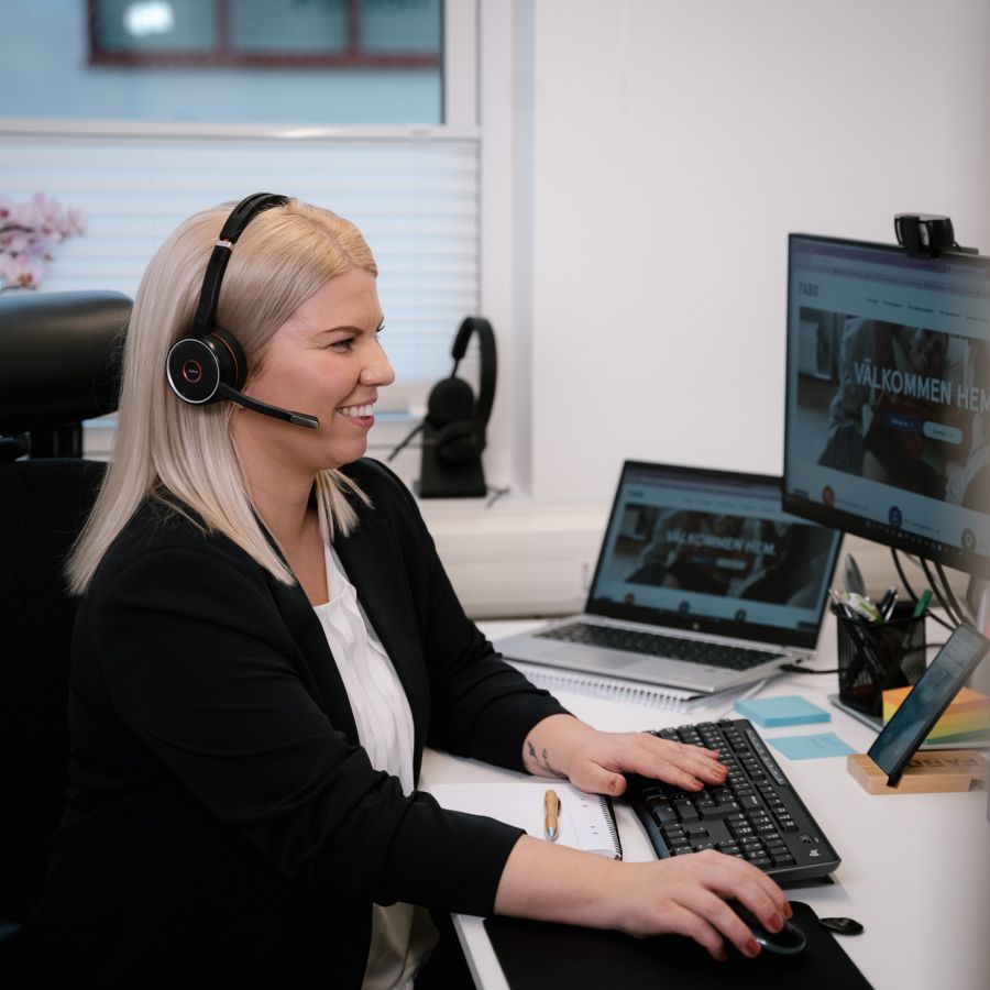 Kvinna framför datorskärm med headset på